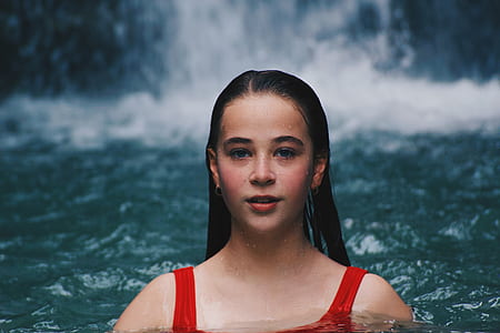woman in red swimsuit in the middle of body of water thumbnail