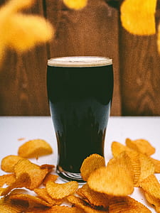 clear drinking glass surrounded of potato chips thumbnail