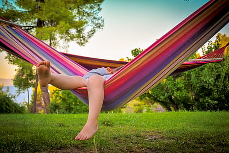 person lying down on multicolored striped hammock thumbnail