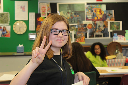 selective focus photography of girl in black shirt with hand sign peace thumbnail