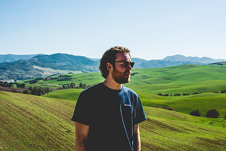 man standing on grass while looking sideways thumbnail