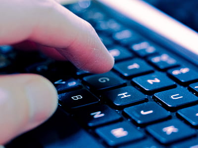 closeup photo of person touching black and white laptop computer keyboard thumbnail