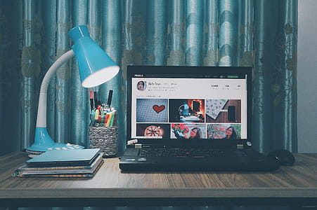 Black Laptop Computer Near Blue Study Lamp on Brown Wooden Table thumbnail