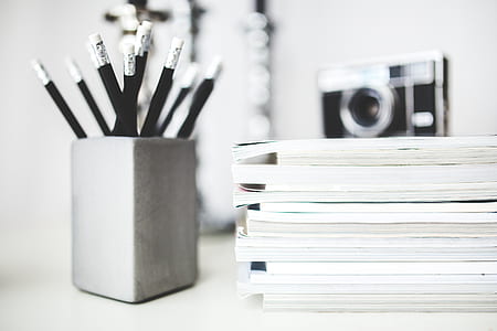 assorted books and black pencils on gray organizer thumbnail