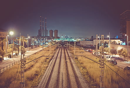 train rail between electric post at nighttime photo thumbnail