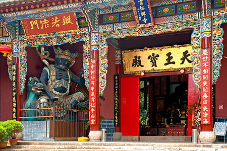 blue and green statue beside building thumbnail