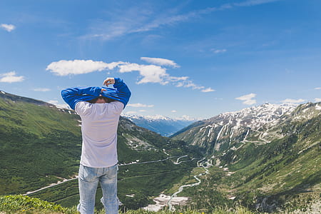 person standing on mountain while changing clothe thumbnail