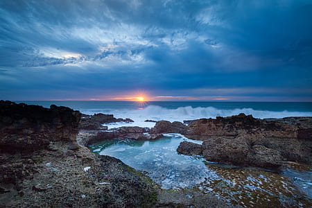 body of water and rock formations during sunset thumbnail