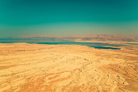 photograph of body of water between brown rock and soil thumbnail