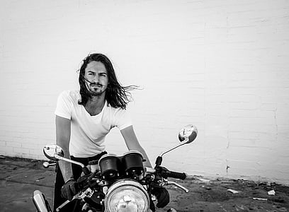 grayscale photo of a man holding motorcycle thumbnail