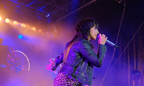 woman singing holding gray wireless microphone thumbnail