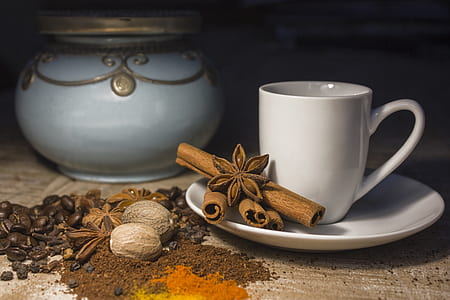 white ceramic teacup with saucer with four brown cinnamon rolls and star anise thumbnail