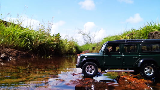 green die-cast SUV toy beside green grasses thumbnail