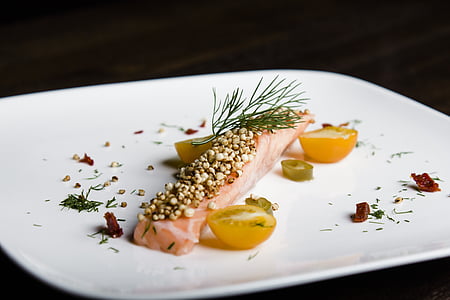 salmon meat with sliced tomato topped with green spice on plate thumbnail
