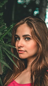 woman on side of green leafed plant thumbnail