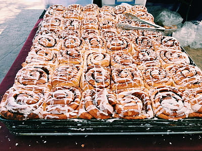 cinnamon rolls placed on maroon tablecloth thumbnail