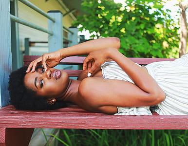 Woman Lying on Brown Wooden Bench thumbnail