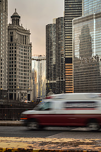 red and white van on road near glass building at daytime thumbnail