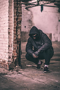 man sitting beside wall thumbnail