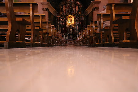 pathway between brown wooden chairs inside cathedral thumbnail