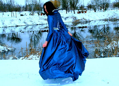woman swaying her royal-blue gown on snow thumbnail