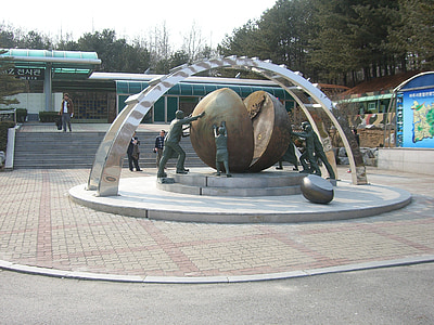group of people pushing globe statue thumbnail
