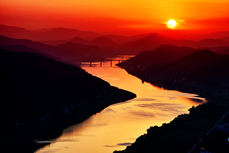 body of water between mountains during golden hour thumbnail