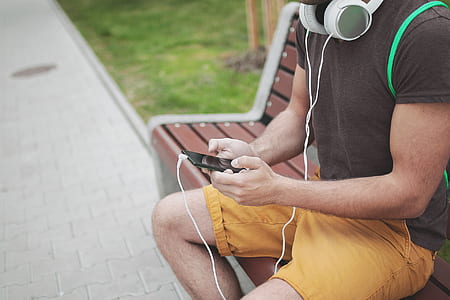 man sitting on bench using smartphone thumbnail