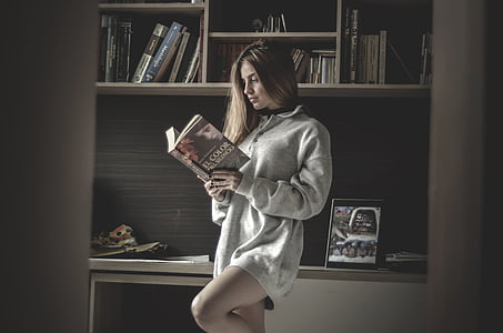 woman in grey loose sweater reading book thumbnail