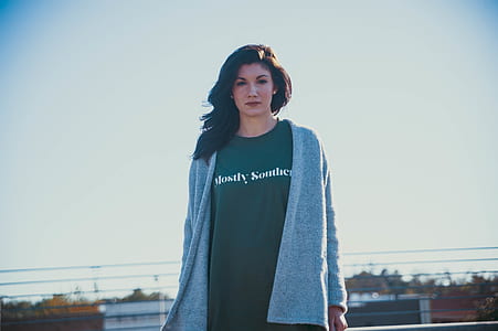 woman wearing green shirt standing near buildings thumbnail