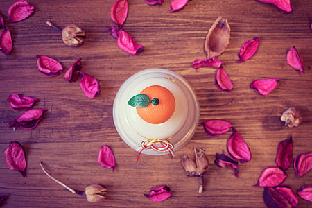 white and orange ceramic container on brown table thumbnail