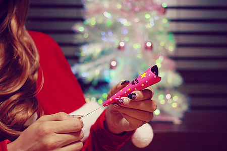 woman wearing red shirt holding pink party popper thumbnail