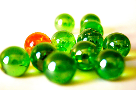 green and orange marble toy on white surface thumbnail