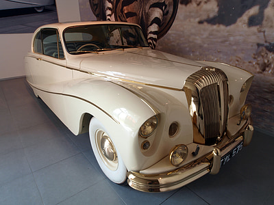 white and gold classic coupe parked inside garage thumbnail