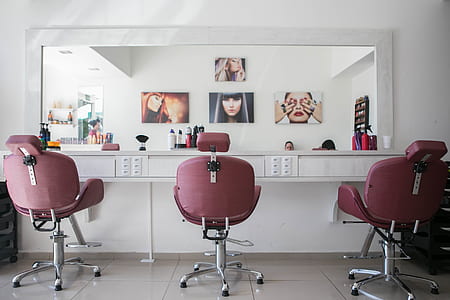 three pink salon chairs in front of large mirror thumbnail