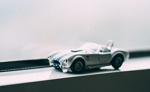 selective focus photo of white and blue convertible coupe die-cast model thumbnail