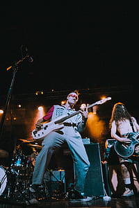 man holding electric guitar on stage thumbnail