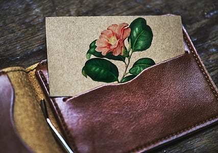red petaled flower card inserted on brown leather wallet thumbnail