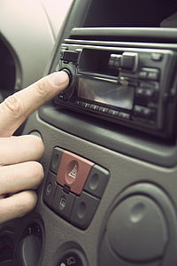 person pressing power button of stereo thumbnail