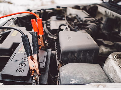 black vehicle engine with alligator clips on vehicle battery thumbnail