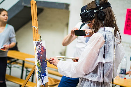 woman wearing virtual reality headset while painting during daytime thumbnail