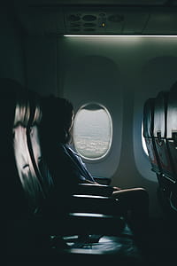 woman seating on black leather chair beside window thumbnail