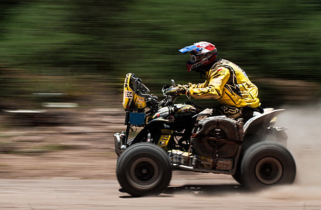 panning photography of man riding ATV thumbnail
