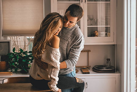 man holding a woman beside white wooden table thumbnail