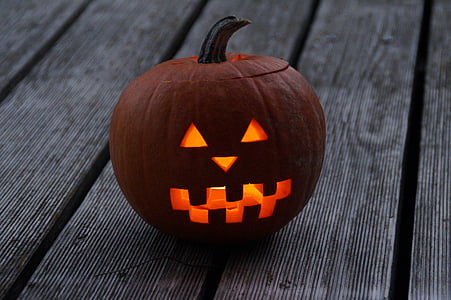 lighted Jack O' Lantern on gray wooden surface thumbnail