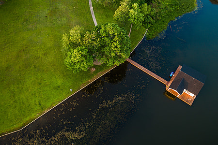 aerial photography of house in the middle of bodies of water near green grass thumbnail
