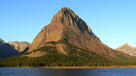 mountain surrounded by forest near water at clear day sky thumbnail