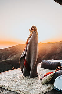 woman covered with blanket standing on rug thumbnail