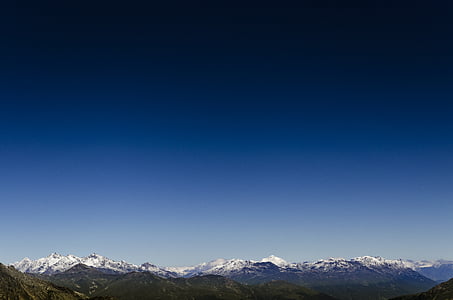 snow-covered mountains under blue sky thumbnail