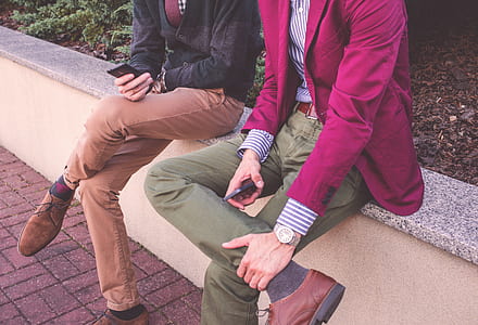 two persons sitting on gray surface thumbnail